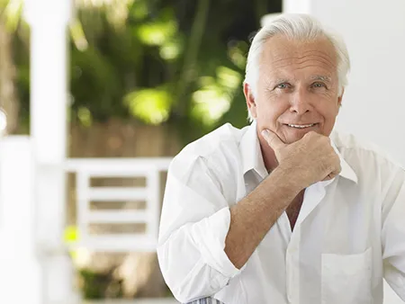 a smiling older man in a white shirt