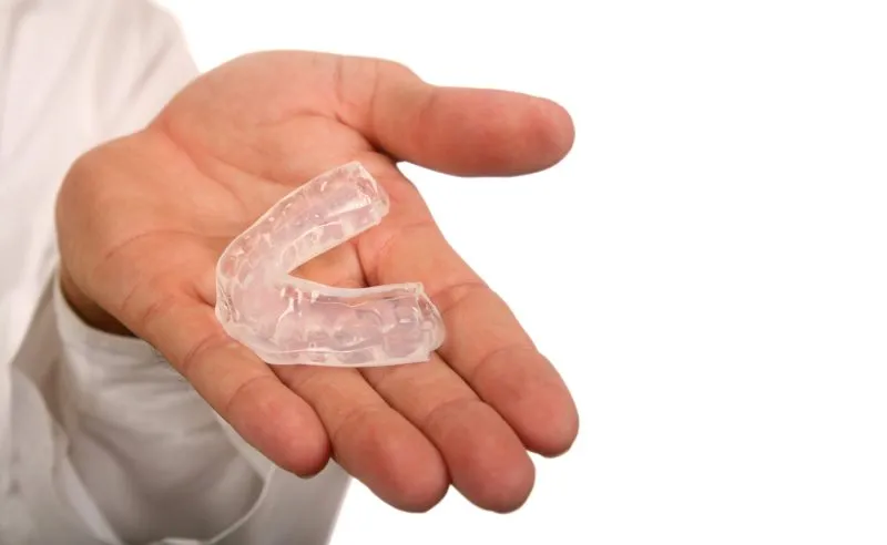 hand holding Invisalign aligner